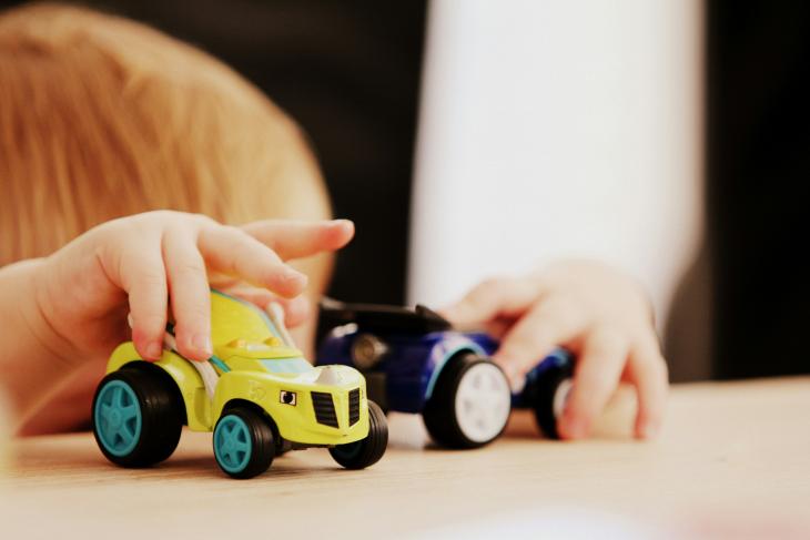 Enfant qui joue avec des voitures